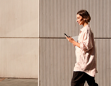 Woman walking and reading on her phone