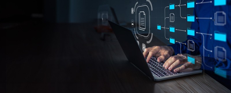 Man with a laptop managing corporate files and information